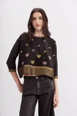 Camisa negra de viscosa con jacquard de lurex, calce amplio y escote redondo. Presenta bordados de corazones dorados y rosados, y guardas doradas en el ruedo y los puños.