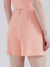 Short de vestir rosado con pinzas, bolsillos laterales y trabillas para cinturón.