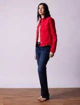 Campera de jean blanca, marca Baccini, con cuello solapa, bolsillos delanteros, abertura central con botones metálicos y terminación desflecada en el ruedo.