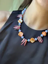 Collar corto con cuentas de nácar teñido, piedras naturales, de acrílico y mostacillas. Se cierra con cadena de acero quirúrgico y ganchito para regular el largo.