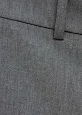 Pantalón gris acampanado de tiro medio con trabillas, bolsillos traseros de ribete y cierre oculto de botón, gancho y cremallera.