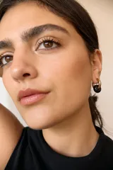 Aros de acero quirúrgico hipoalergénico con piedras naturales azules. Diseño de aro con dije circular colgante.