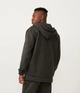 Campera de algodón gris oscuro jaspeado, con cierre frontal de cremallera, capucha con cordones trenzados y bolsillo canguro.