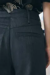 Pantalón de jean azul oscuro, de tiro medio, corte wide leg y bolsillos laterales.