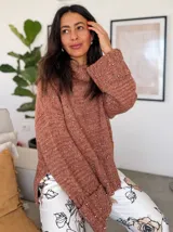 Sweater de punto color ladrillo, con cuello alto y mangas largas con puños acampanados. Decorado con perlas sintéticas en el frente y en los puños.