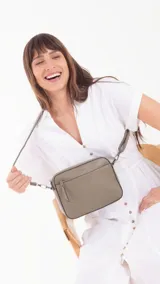 Bandolera color marrón claro de cuero sintético con diseño texturizado geométrico en el frente. Cuenta con un bolsillo frontal con cierre, un bolsillo trasero con cierre y un compartimento principal con divisiones. Incluye una correa extensible.