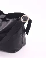 Bolso marrón de cuero con textura, tipo shopper, con correa regulable para usar al hombro o cruzada. Tiene un bolsillo espacioso con cierre que divide el interior en tres compartimentos.