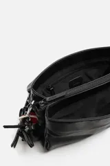 Bandolera negra con solapa y cierre magnético. Incluye llavero decorativo con forma de estrella. Tiene correa de hombro ajustable y extraíble. El interior cuenta con tres compartimentos, uno con bolsillo con cierre.