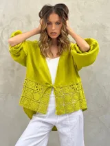 Blusa marrón de lino con escote en V, mangas largas abullonadas y detalle de encaje en la parte inferior.