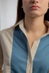 Camisa color beige con solapas y cierre con botones.