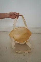 Bolso tote pequeño de lona color crudo con doble asa corta. Decorado con parches termoadhesivos de gafas de sol, inicial con corona, cóctel y cangrejo.