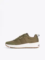 Zapatillas de running Tommy Hilfiger color verde oliva, con exterior de punto y poliéster, interior de poliéster, plantilla extraíble de goma termoplástica reciclada, suela de EVA dentada y trabilla para calzar.