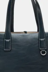 Bolso shopper azul marino con doble asa corta y correa larga de tela color crudo. Tiene detalle de pespuntes blancos y tira con anilla metálica.