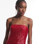 Vestido corto sin breteles, color rojo, cubierto de lentejuelas brillantes.