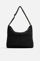 Bolso de hombro negro fabricado en tejido técnico de nylon. Tiene un compartimento principal con cierre de cremallera, un bolsillo interior con cremallera y un bolsillo frontal con cremallera. El asa de hombro es ajustable.