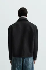 Sobrecamisa de hombre regular fit confeccionada en tejido con estructura irregular en tonos beige, marrón y negro. Tiene cuello solapa, manga larga con puños abotonados, bolsillos laterales y cierre frontal con cremallera.