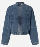Campera de jean azul con cuello alto, cierre frontal con cremallera, mangas largas y recortes.