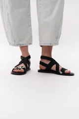 Sandalias negras con tiras cruzadas de cuero y pelo vacuno con estampado animal print.