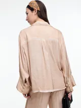 Camisa gris de manga larga confeccionada en viscosa teñida en frío, con efecto gastado. De corte relajado, con bolsillo delantero y puños amplios.