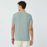 Remera polo de punto color celeste con textura tipo waffle, de corte clásico, manga corta y cuello con botones.