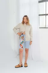 Camisa color avellana de cuero ovino italiano, de corte recto, con cuello camisero, cierre frontal con botones a presión y bolsillo de parche en el pecho.