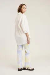 Camisa blanca de mangas largas con puños abotonados, cuello clásico y bolsillo en el pecho.