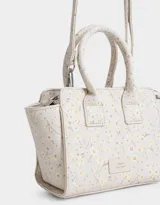 Cartera mini city de cuerina negra estampada con flores blancas. Tiene correa desmontable y doble asa corta.