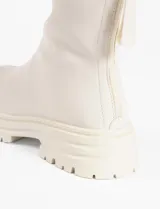 Botas cortas color crema, de cuero vegano, con suela track y cierre trasero con cremallera.