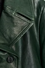 Blazer de piel color verde oscuro, de corte cruzado con doble botonadura negra, cuello solapa de muescas y manga larga.