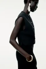 Top tipo chaleco negro de Zara Woman Collection, con cuello redondo y sisa. Presenta costuras a contraste y cierre frontal con botones.