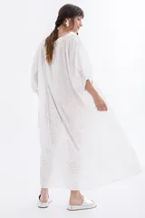 Vestido largo blanco con bordado calado tipo broderie, escote en V y mangas largas abullonadas.