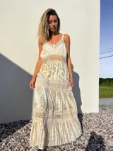 Vestido largo de estilo bohemio, color crudo con detalles dorados y crochet.
