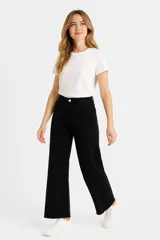 Pantalón de jean color gris oscuro, de corte ancho y tiro alto, con ruedo desflecado.