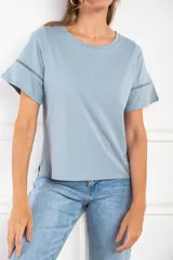 Remera celeste de algodón peinado, con cuello redondo y mangas cortas con detalle de calado.
