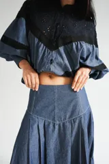 Falda larga de tela de jean con diseño de caderín y tablas.