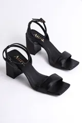 Sandalia de cuero color nude, con tira delgada sobre los dedos, pulsera al tobillo con hebilla y tacón cuadrado.