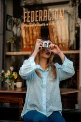 Camisa color beige con bordado inglés, de corte recto, manga larga abullonada con puño y cuello camisero.