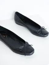 Ballerinas de cuero negro con punta cuadrada y moño decorativo.