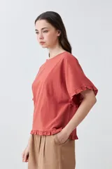 Blusa blanca con volados en mangas y ruedo.