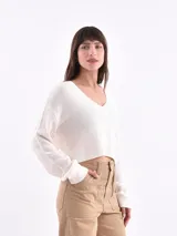 Buzo de tejido de punto color rojo, con cuello redondo y manga larga.