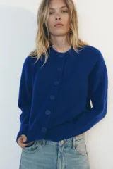 Chaqueta de punto color marrón con aberturas laterales y cierre frontal con botones.