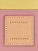 Bolso de mano en cuero con diseño de parches en tonos rosa y amarillo.