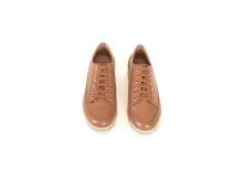 Championes acordonados de cuero color caramelo con suela blanca. El cuero es curtido especialmente, lo que ofrece un calzado suave y liso. Su forro interior también es de cuero, lo que les permite absorber mejor el sudor y prevenir los malos olores. Las plantillas están hechas de látex de aire, un material que mantiene los pies frescos y secos.