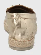 Mocasines dorados de cuero con adorno metálico dorado y suela de yute.