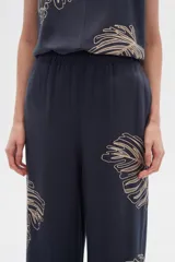 Pantalón ancho de poliamida color azul marino con bordado de hojas color beige.