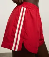 Short deportivo femenino modelo runner, color marrón chocolate con cintura elástica y rayas laterales color crema.