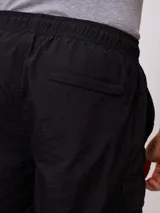 Bermuda color beige de corte recto con bolsillos cargo laterales y cintura elastizada con cordón ajustable.