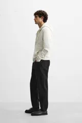 Pantalón de jean celeste de corte slim fit y tapered, con cinco bolsillos, efecto lavado y cierre frontal con cremallera y botón.