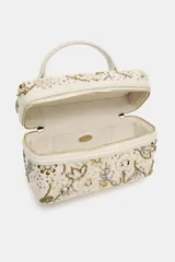 Bolso rígido color blanco con apliques de lentejuelas y cuentas doradas y plateadas. Tiene asa de mano y asa de cadena extraíble para usar como bandolera. Cierre con cremallera.