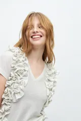 Remera color crudo con escote en V y volados laterales.